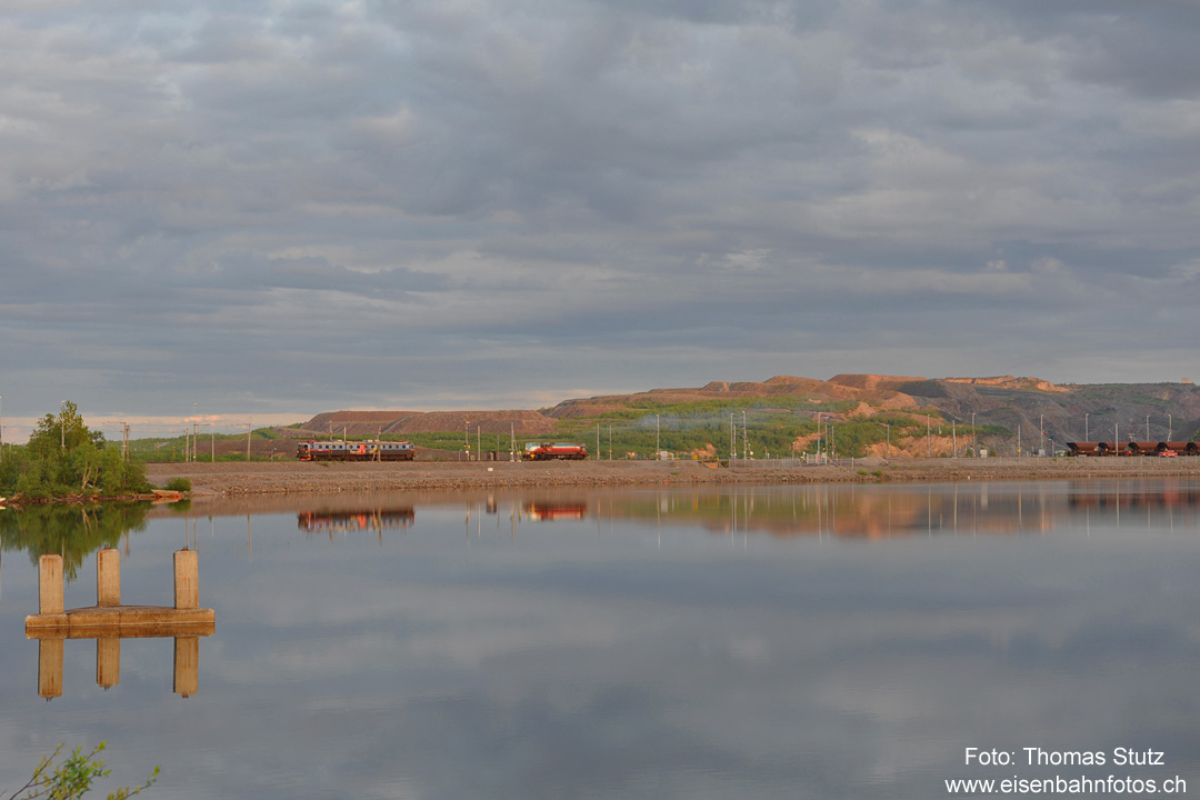 Blick über den See
Während eine Dm3 auf die Bereitstellung des nächsten Erzzuges wartet, ist die Rangierlok auf dem Weg, um einen Leerzug zu holen.
