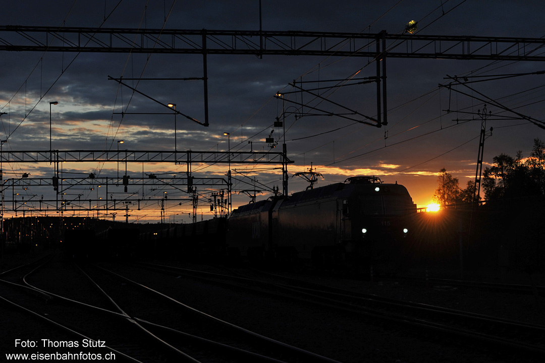 IORE mit Mitternachtssonne
Inzwischen ist es 0:15 Uhr. Eine IORE durchfährt mit ihrem Leerzug den Bahnhof Richtung Erzmine.
