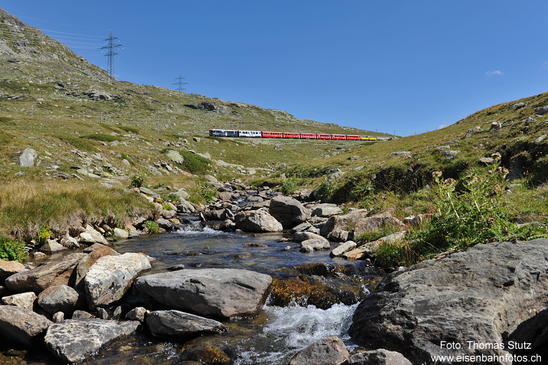 bunter Zug auf Talfahrt
Die beiden Werbetriebwagen "100 Jahre Bernina" und "Unesco Welterbe" vor einem Regio, der am Schluss offene Aussichtswagen führt.
