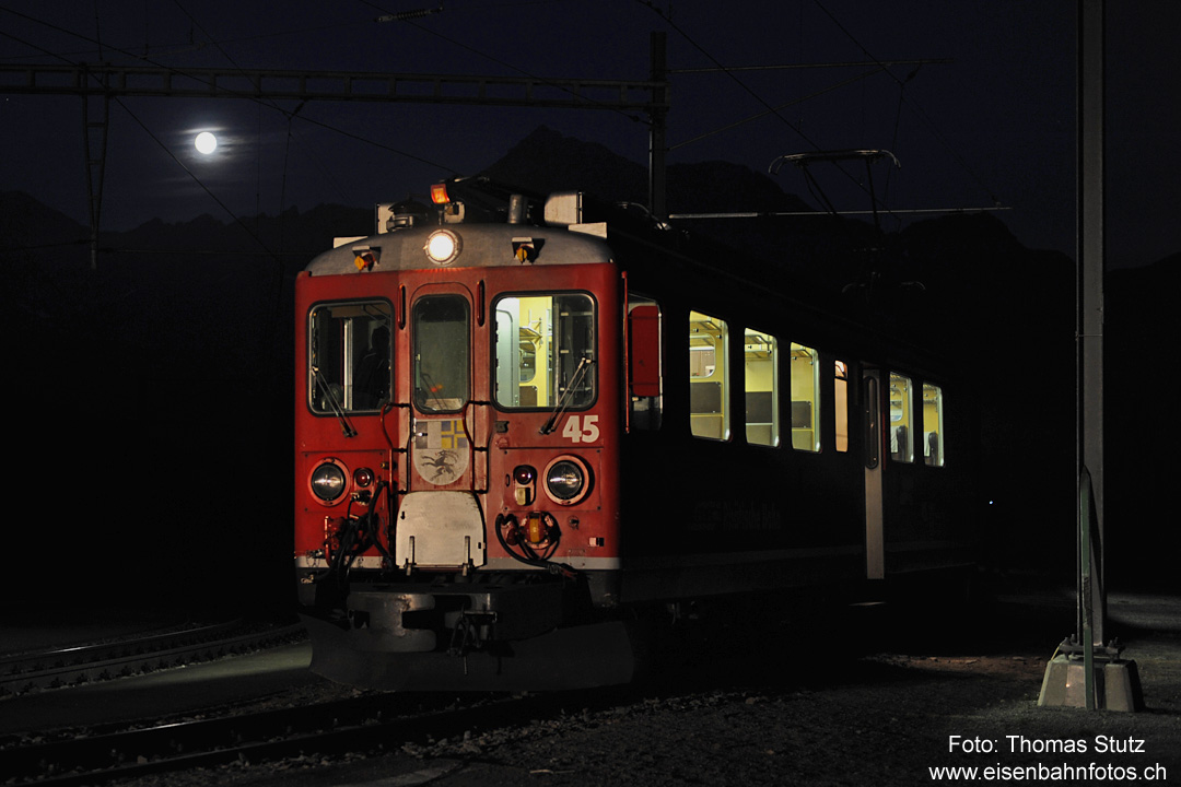 ABe 4/4 II mit Mond
Für einen Bahndiensteinsatz sind 2 ABe 4/4 II am Abend in Alp Grüm eingetroffen und warten auf ihren Einsatz.
Inzwischen ist der Mond aufgegangen (am Tag zuvor war Vollmond) und für die richtige Beleuchtung
der Triebwagenfront sorgt eine Baumaschine, die mit Vollbeleuchtung auf die Strecke fährt.
