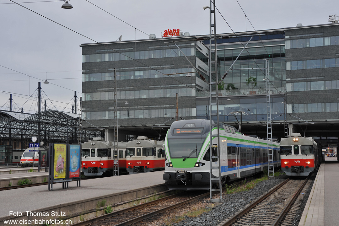 S-Bahn Helsinki
In den kürzeren Gleisen auf der Westseite des Bahnhofs warten diverse S-Bahnen auf die Abfahrt.
Der Buchstabe an der Front des Zuges gibt dabei Auskunft über die befahrene Strecke, die Haltebahnhöfe und das Ziel.
