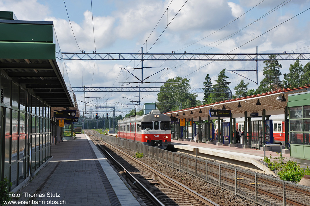 Bahnhof Huopalahti
Bis Huopalahti verläuft die Strecke viergleisig, unmittelbar nach dem Bahnhof zweigt die Strecke nach Vantaankoski ab.
Leider (aus fotografischer Sicht) sind auf vielen Bahnhöfen in Finnland Gitterabschrankungen zwischen den Gleisen vorhanden.
