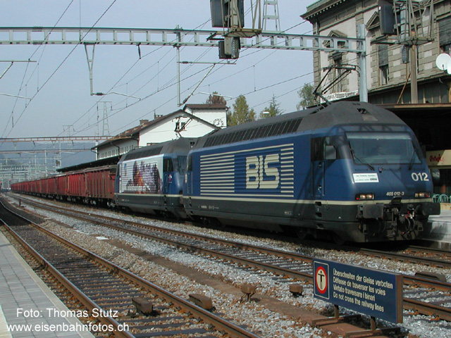 3250 Tonnen in Fahrt
Nicht irgendein Güterzug durchfährt hier Liestal. Der Tonerdezug 41065 ist zwar mit 500 m nicht der längste, aber der mit grossem Abstand schwerste Güterzug in der Schweiz. Die 2 Re 465 ziehen bis zu 3250 Tonnen von Basel Richtung Lötschberg. Ab Spiez verkehrt der Zug in 2 Teilen mit total 5 Loks bis Kandersteg. Dort werden die beiden Züge wieder zusammengehängt und der Zug verkehrt mit 1 Re 465 an der Spitze sowie 2 Re 465 am Schluss (als Bremsloks) bis Domodossola.
