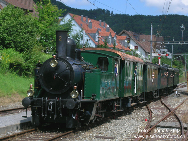 Einfahrt in Bäretswil
Einfahrt des Dampfzuges aus Bauma zur Kreuzung in Bäretswil. Weil der Zug aus Hinwil verspätet war, fuhr der Zug aus Bauma ausserplanmässig als erster ein. Da in Bäretswil nur Handweichen existieren, muss der Vorstand bei einer Umdisposition (nochmals) zur Einfahrweiche laufen, um diese umzustellen. (Die Kommunikation mit dem Fahrpersonal der Züge erfolgt allerdings per Handy ...)
