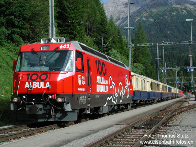 Jubiläumszug 2003
Jubiläumszug 2003 während des Aufenthaltes im Bahnhof Bergün/Bravuogn. Auf der Lok im Jubiläums-Anstrich "100 Jahre Albula und Ruinaulta" ist auf der rechten Seite der Streckenverlauf zwischen Bergün/Bravuogn und Preda dargestellt. Auf der Lok befinden sich übrigens vorne und hinten je 2 Lautsprecher, mit denen auf der Fahrt auch akustisch auf das Jubiläum aufmerksam gemacht wurde.
