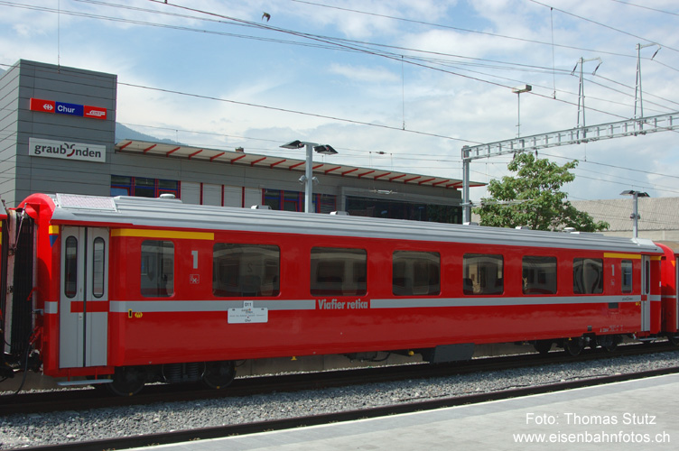 Neues Wagendesign
Die Reisezugwagen erhalten ein leicht abgeändertes Design. Der Namenszug (neu ohne RhB-Symbol) wurde ins untere Fensterband integriert und mit einem "Graubünden"-Schriftzug ergänzt. Ausserdem wurde der gelbe "1.Klasse-Strich" auf die Wagenenden reduziert.
