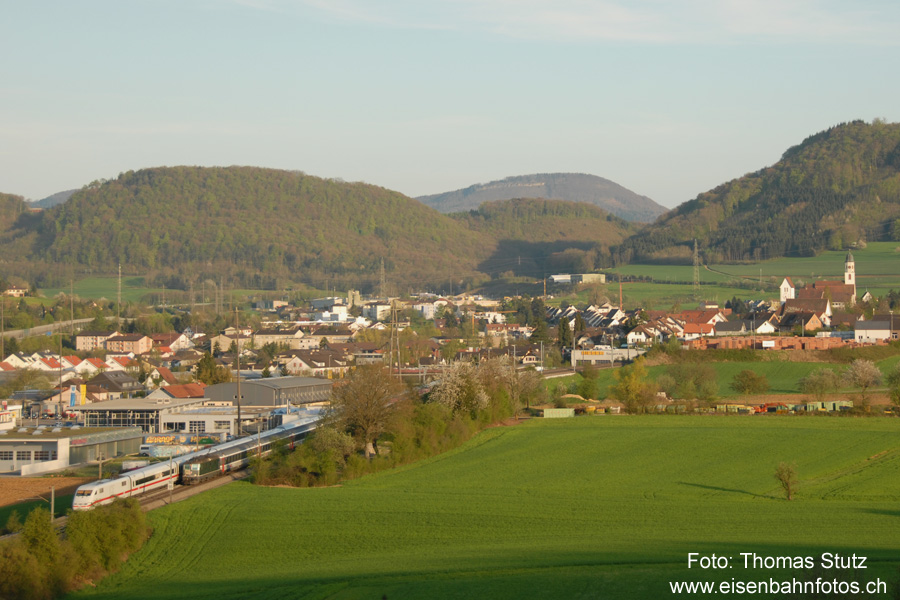 Begegnung mit ICE
Es passt genau! Die untergehende Sonne macht sich zwar von Minute zu Minute durch mehr Schatten bemerkbar, aber die Verspätung des "Transalpin" beträgt genau soviel, dass es unterhalb von Frick zur Begegnung mit dem umgeleiteten ICE kommt.
